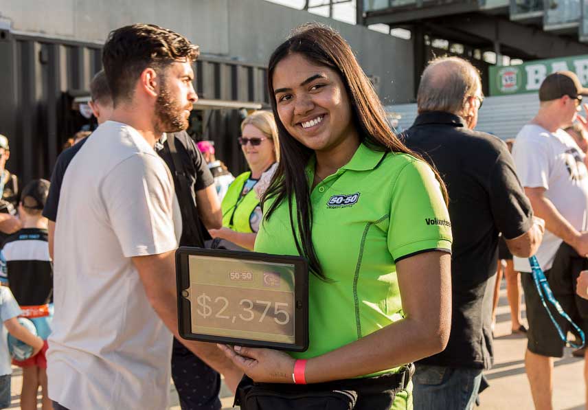 50-50 volunteer holding a tablet showing the raffle total